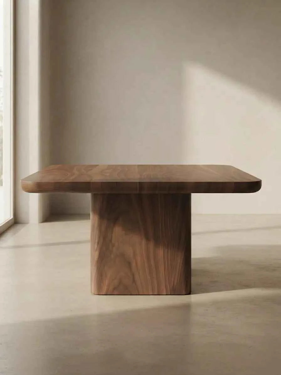 Side view of a wooden coffee table with a pedestal base